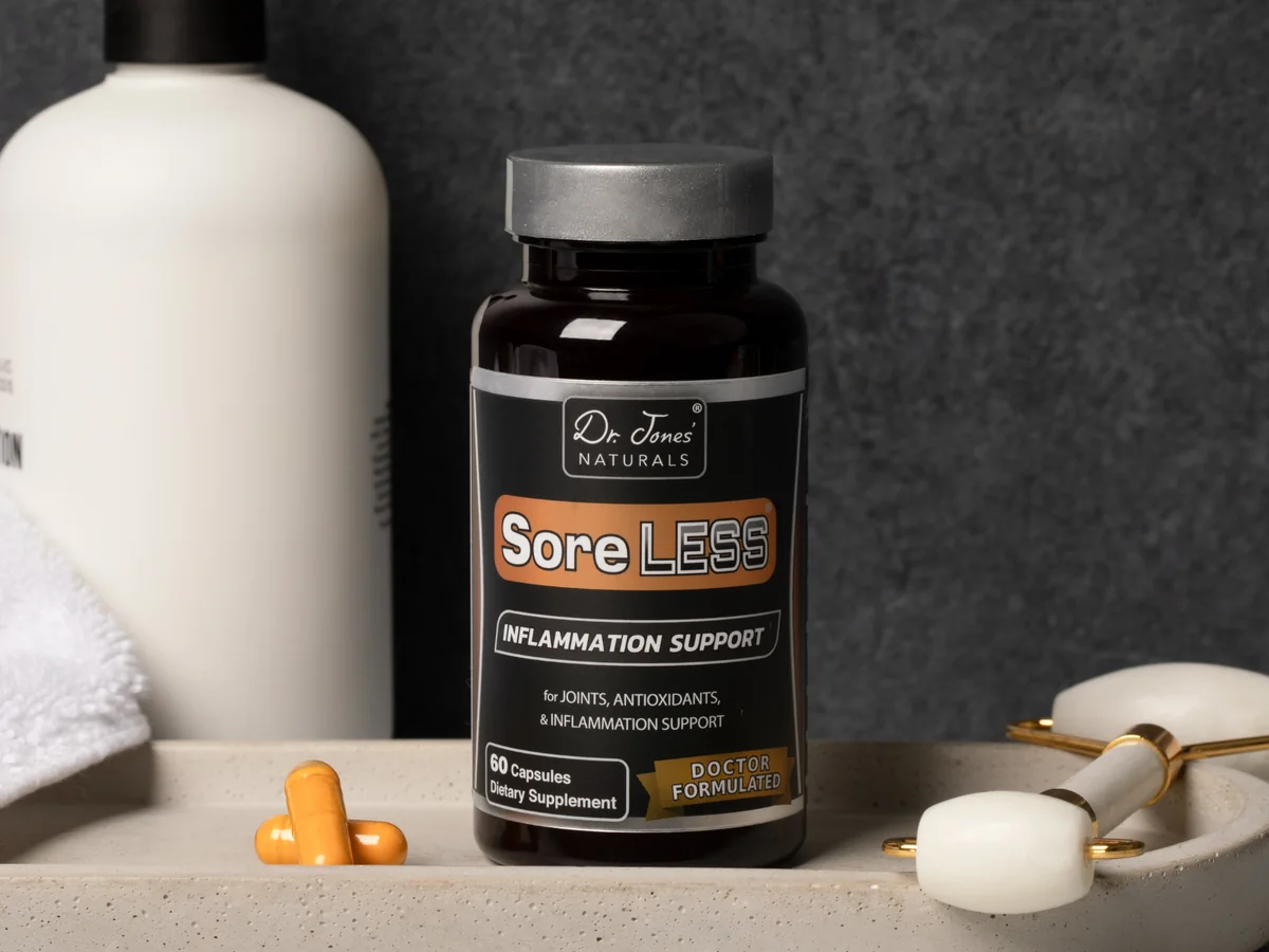 A bottle of SoreLESS and two capsules on a stone tray beside a white pump bottle